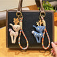 Deer charm keychain hanging from a set of keys on a wooden surface
