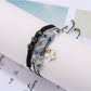 Lovra bracelet with butterfly pendant worn on wrist alongside other bracelets
