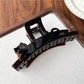 Beau cat-shaped claw clip resting on a white surface with soft lighting