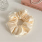Gifty satin tulle ruffled scrunchie held in hand showing size and fabric details