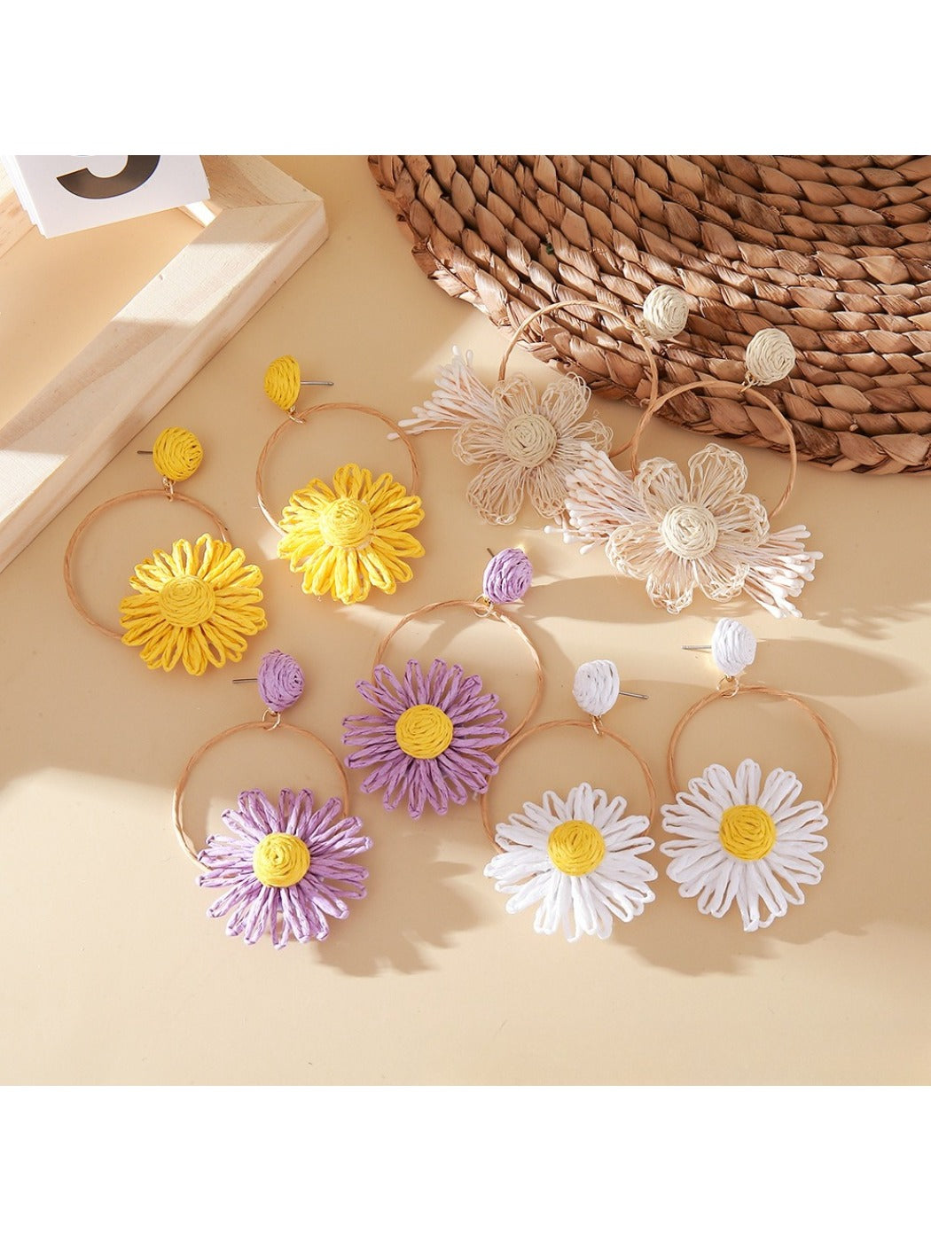 Close-up of Earedge woven raffia circle flower earrings on white background