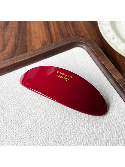 Beau acetate oval hair clip displayed open to show metal clasp and hinge