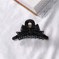 Beau acetate bow shaped claw clip angled to show thickness and design
