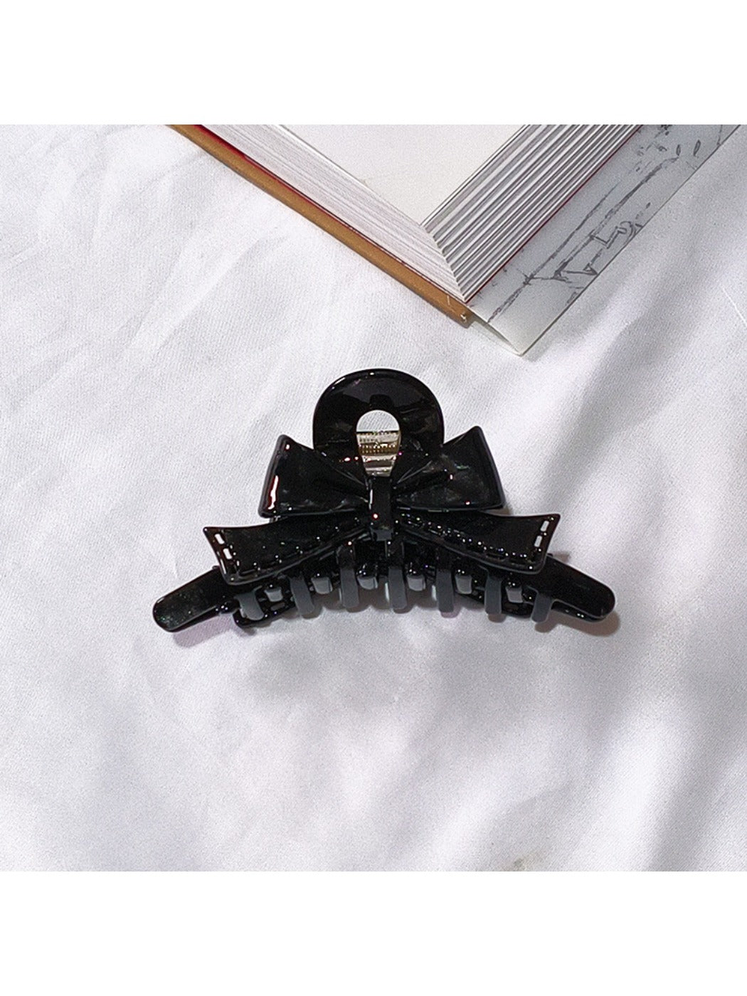 Beau acetate bow shaped claw clip angled to show thickness and design