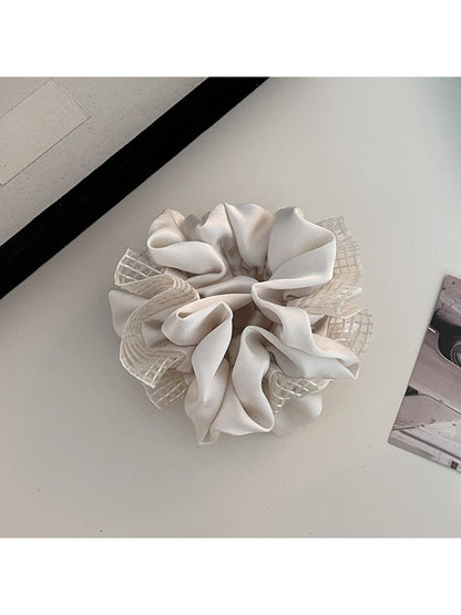 Gifty scrunchie worn in a ponytail highlighting its fashionable cut out and ruched style
