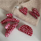 Beau pink leopard print hair clip held in hand showing size and pattern