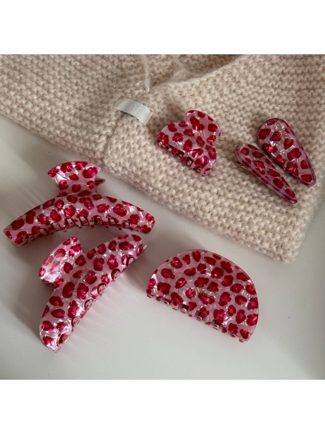 Beau pink leopard print hair clip held in hand showing size and pattern