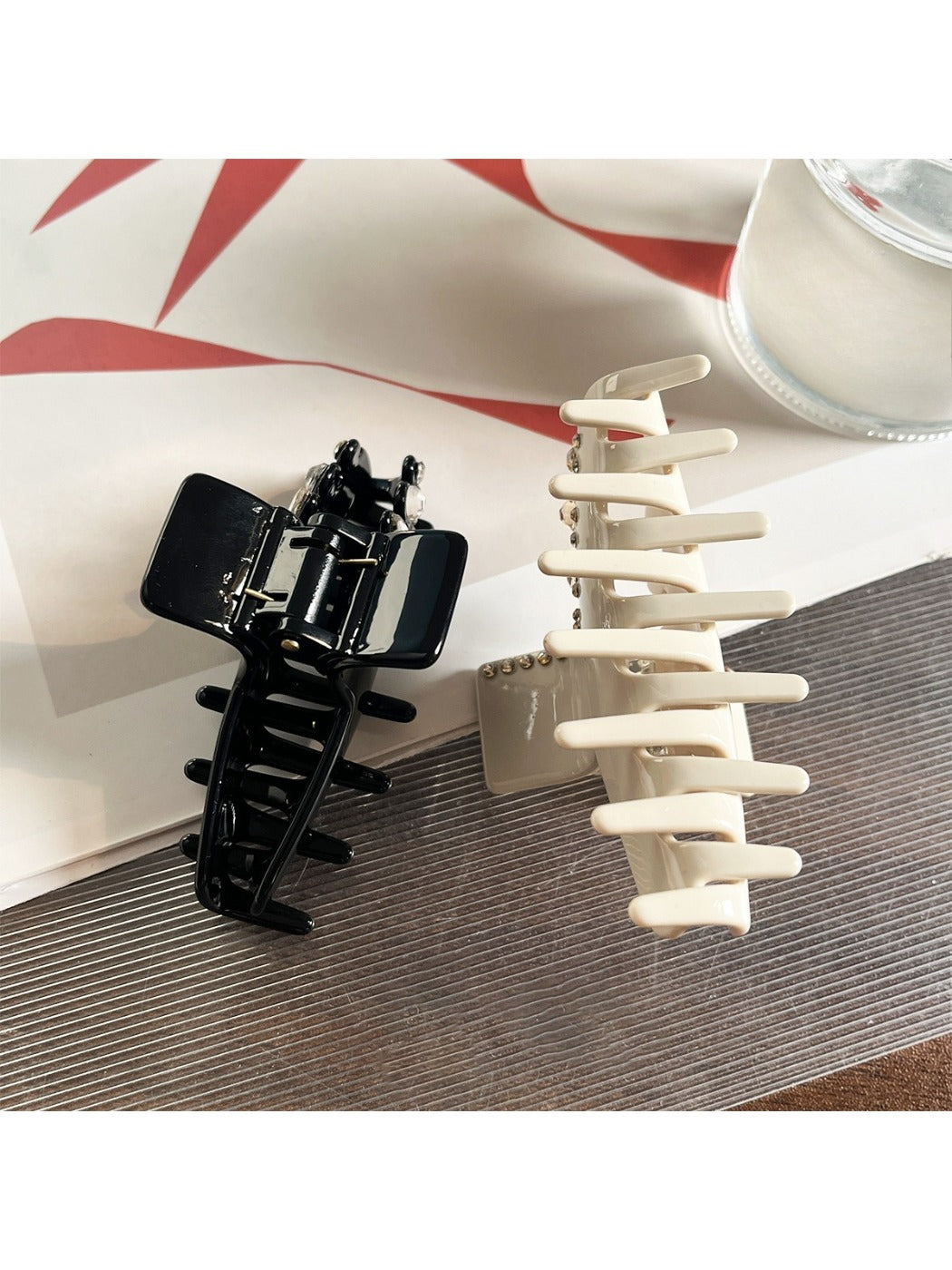Beau claw clip holding hair, showcasing rhinestone accents and glossy acetate finish