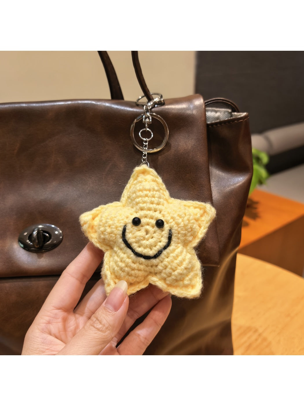 Yarn star keychain displayed on a wooden surface with soft lighting