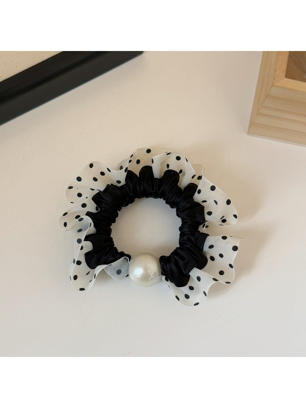 Hand holding a bundle of plaid and polka dot hair ties in different colors
