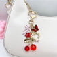 Close-up of cherry bow charm showing detailed red cherries and textured pink bow