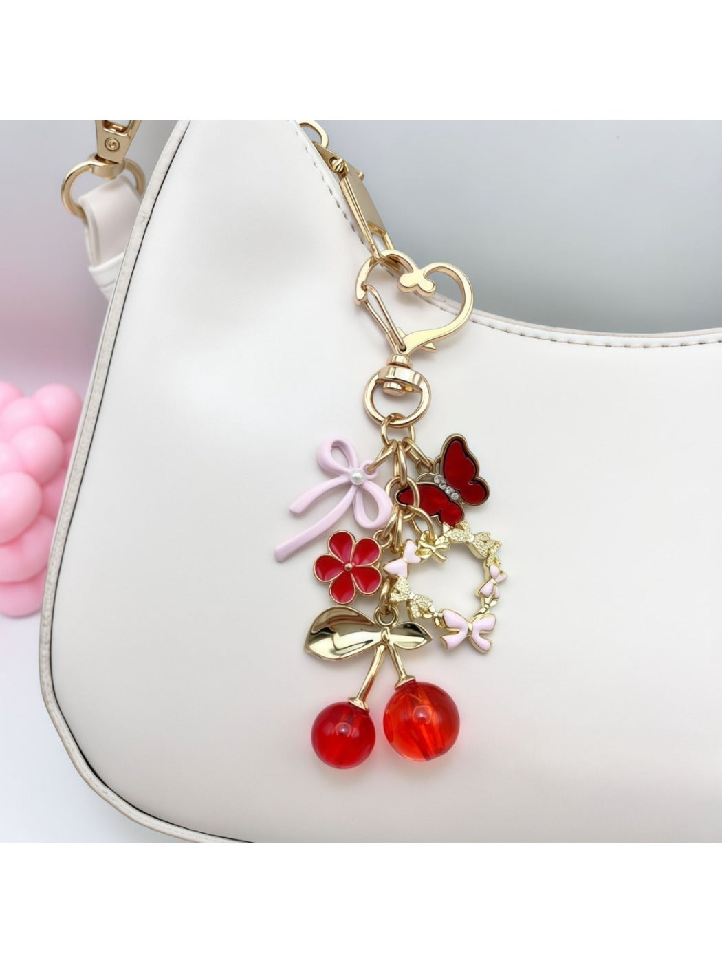 Close-up of cherry bow charm showing detailed red cherries and textured pink bow