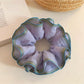 Close-up of purple ruffled fabric texture on scrunchie