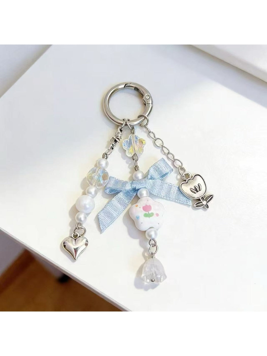 Floral bow charm keychain displayed on a white background highlighting colors and texture