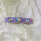 Multiple colorful square hair clips clipped into long blonde hair