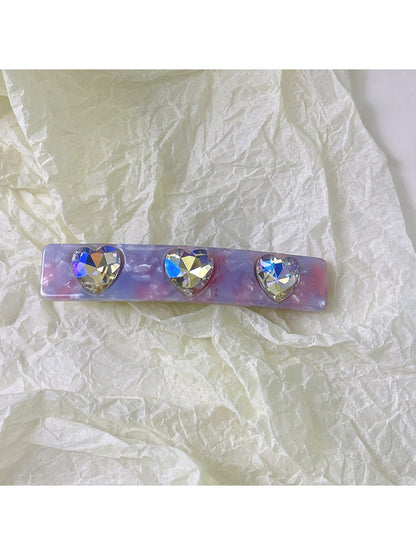 Multiple colorful square hair clips clipped into long blonde hair