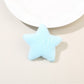 Plush star hair clip resting on a wooden surface with natural lighting