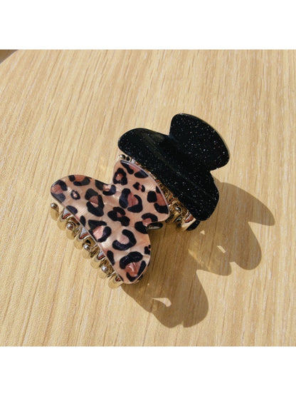 Close-up of black glitter and leopard claw clip showing textured surface