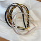 Vintage leopard print hairband with knotted detail on a white background
