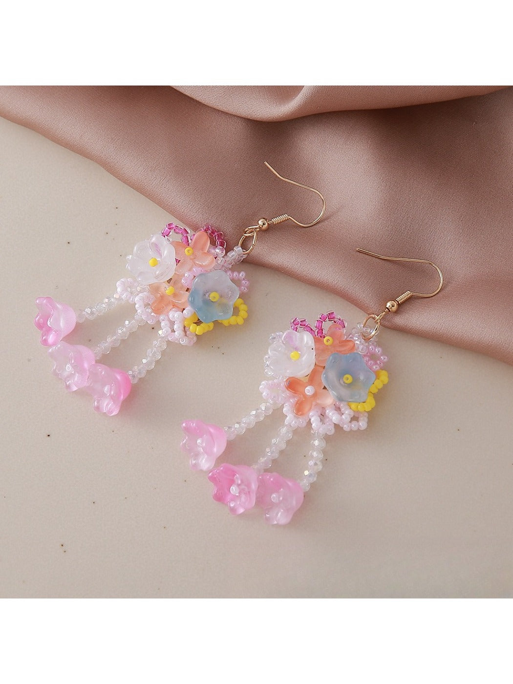 Side view of small beaded flower earrings showing gold accents and detailed petals