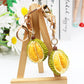 Durian keychain hanging from a set of keys on a wooden surface