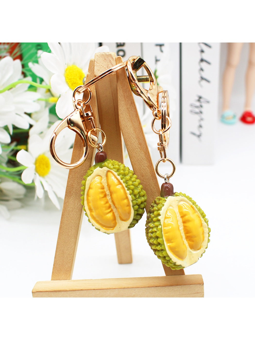 Durian keychain hanging from a set of keys on a wooden surface
