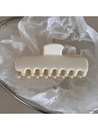Beau hair clip held in hand displaying size and colorful details