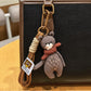 Bear keychain placed on a wooden surface with natural lighting