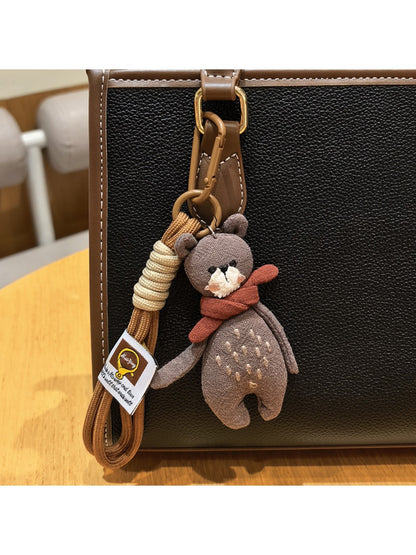 Bear keychain placed on a wooden surface with natural lighting