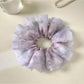 Purple printed scrunchie styled with casual outfit on a wooden surface