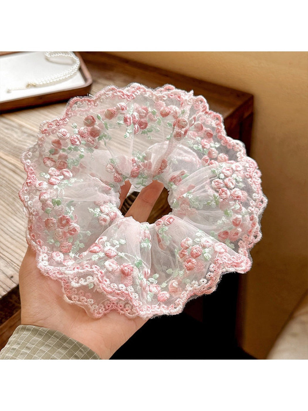 Close-up of a sweet pink ruffled scrunchie made of soft fabric