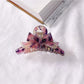 Beau acetate bow shaped claw clip resting on reflective surface