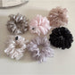Scrunchie wrapped around a ponytail on a model with natural hair
