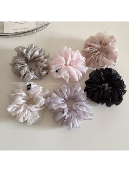 Scrunchie wrapped around a ponytail on a model with natural hair