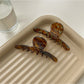 Side view of Beau brown acetate claw clip displaying spring mechanism