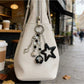 Close-up of the star smiley face keychain showing smooth metal finish
