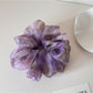 Multi color tulle scrunchie displayed flat to show full circular shape and colors