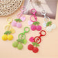 Close-up of Keypus cute cherry charm keychain with red cherries and green leaves