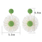 Earedge raffia flower shaped drop earrings displayed hanging on a stand