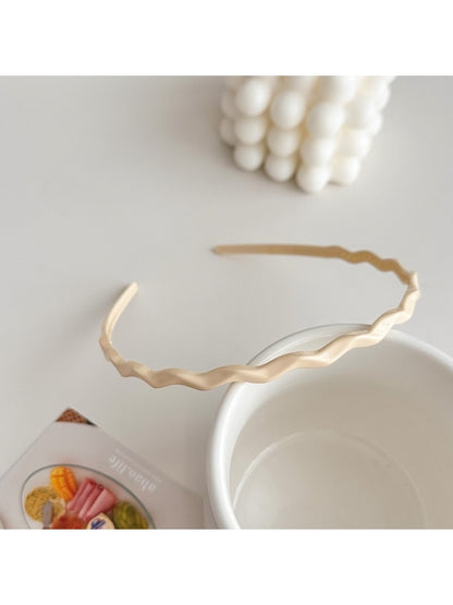 Gifty solid color wavy headband placed next to matching accessories