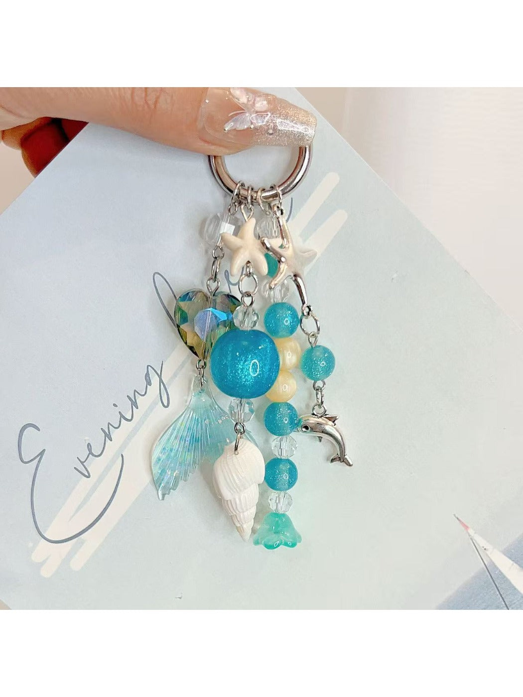 Close-up of ocean-themed charm featuring wave design on a silver keychain