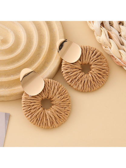 Earedge round drop earrings placed on a textured fabric background