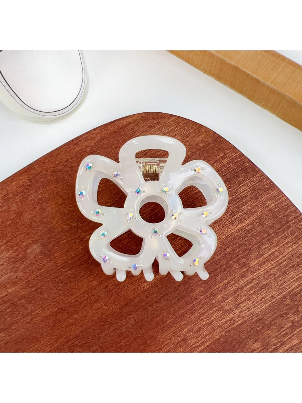 Beau flower shaped hair claw clip packaged in clear plastic box