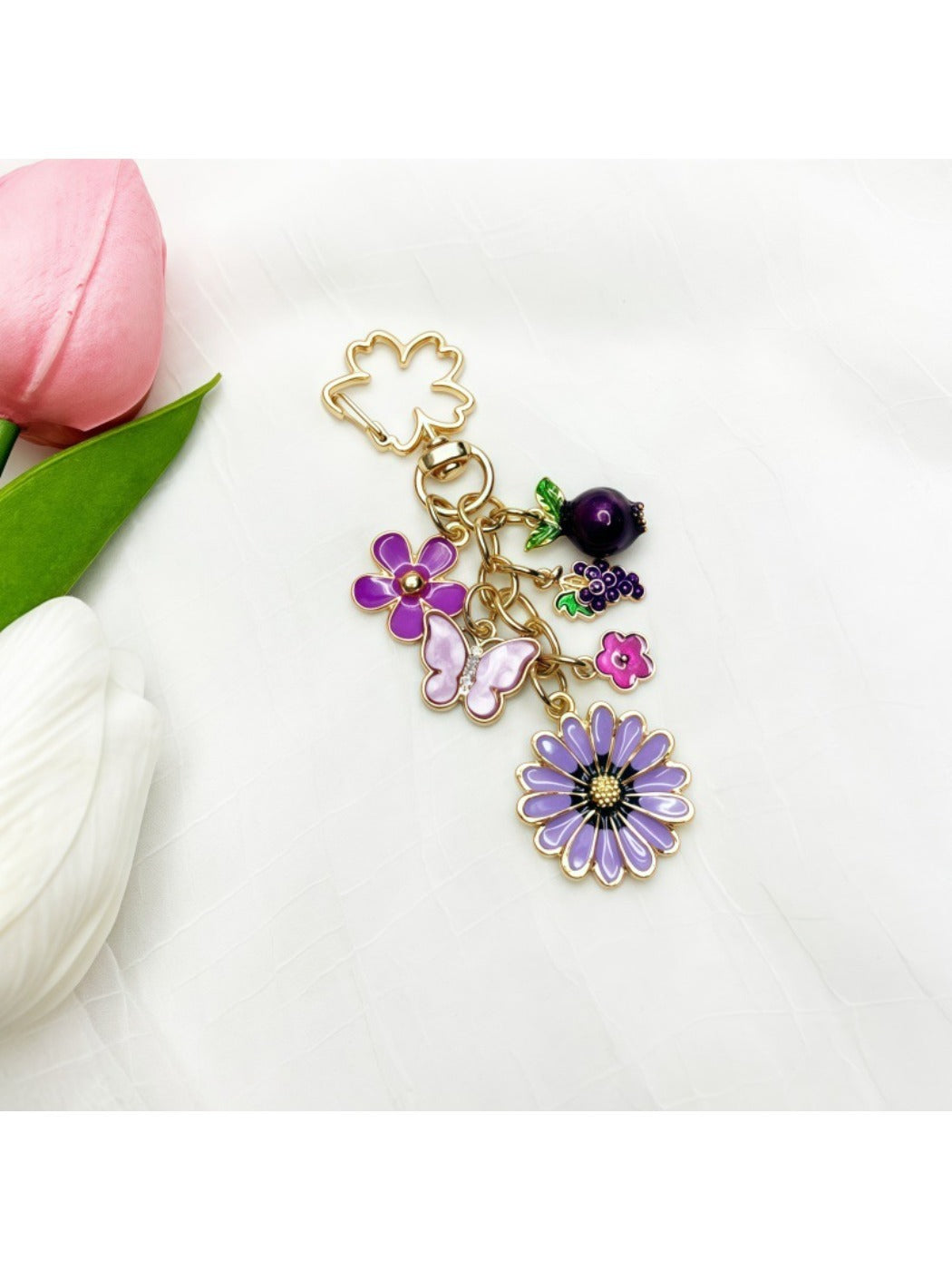 Side view of gold keychain featuring a small daisy flower charm
