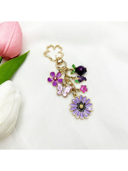 Side view of gold keychain featuring a small daisy flower charm