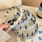 Minimalist plaid headband with neutral tones displayed on a white background