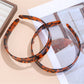 Chic leopard print headband with twisted knot detail on a white background