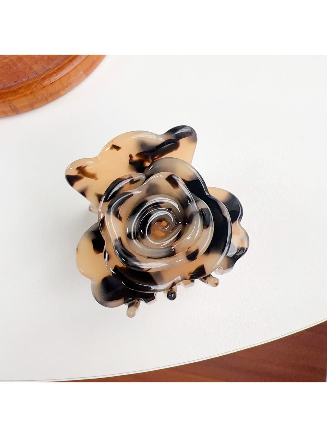 Beau claw clip resting on a wooden surface, highlighting its modern minimalist design
