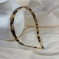 Vintage leopard print hairband displayed on a wooden surface