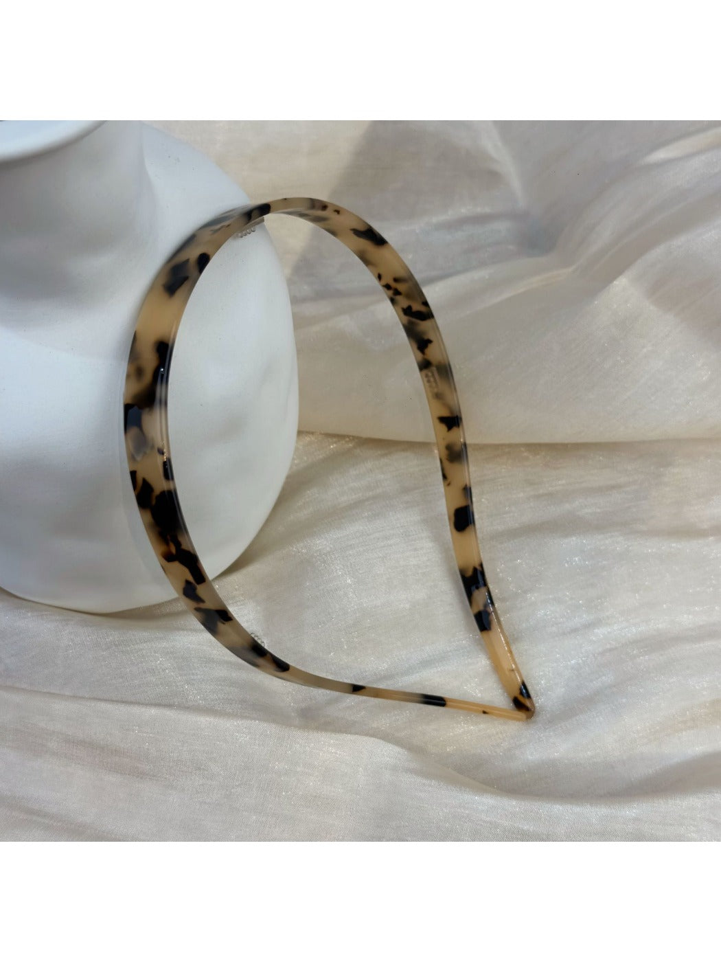 Vintage leopard print hairband displayed on a wooden surface